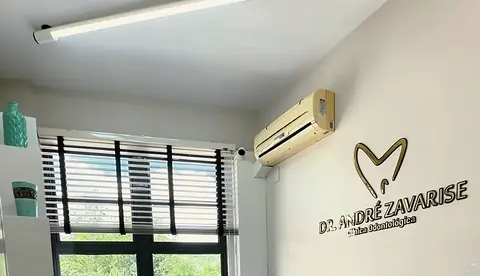 Sala do Dr. André, com o letreiro dourado na parede e janelas para a cidade