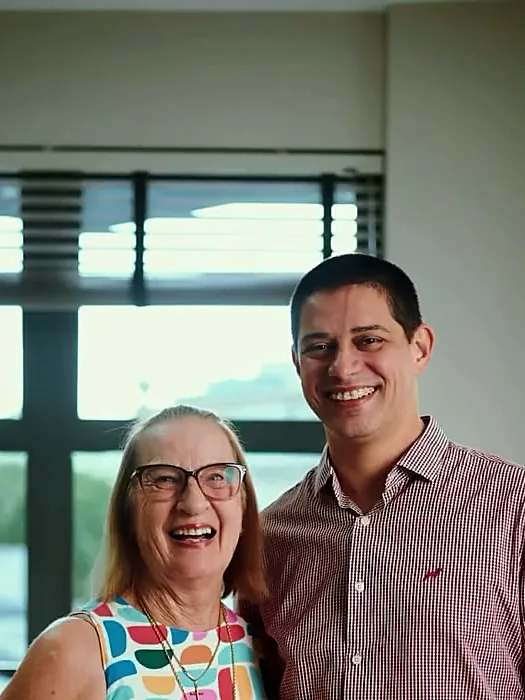 Dr. André abraçado a uma paciente sorridente no consultório